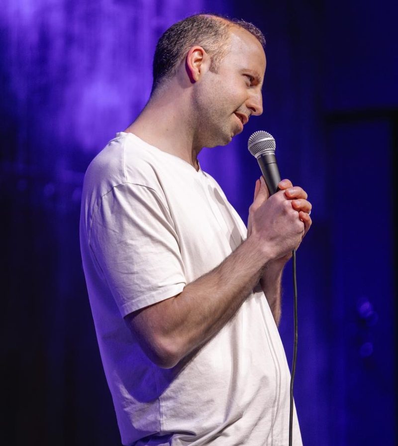 Hal Sadi performing on stage with purple stage lighting